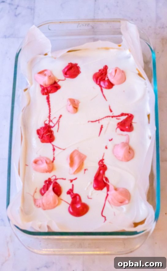 Sweet Valentine's Millionaire Bars 7 Small dollops of red and pink melted chocolate carefully placed over a smooth layer of white chocolate, creating a beautiful contrast on the Valentine's Day Millionaire Bars.