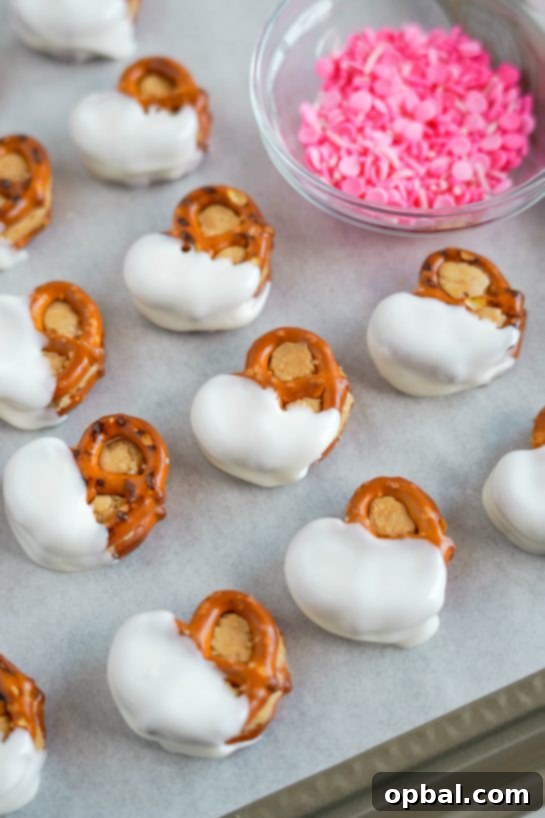 Sweetheart Pretzel Bites 7 White chocolate dipped pretzel bites, waiting for festive sprinkles to be added.