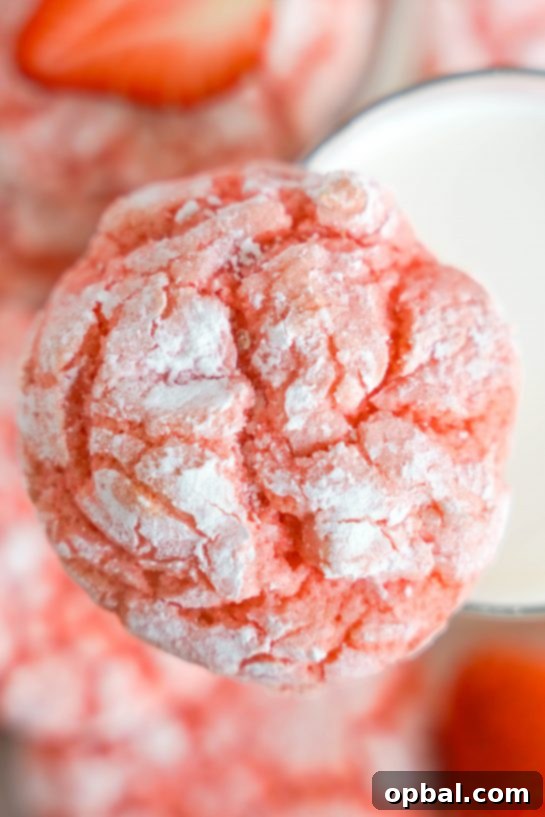 Luscious Strawberry Crinkles 11 A delightful close-up shot of Strawberry Crinkle Cookies covered in powdered sugar, ready to be enjoyed on Valentine's Day.