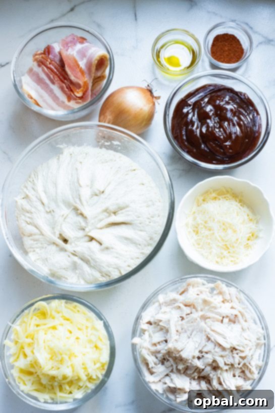 Ingredients for Sheet Pan BBQ Chicken Pizza laid out, including chicken, BBQ sauce, cheese, and dough.