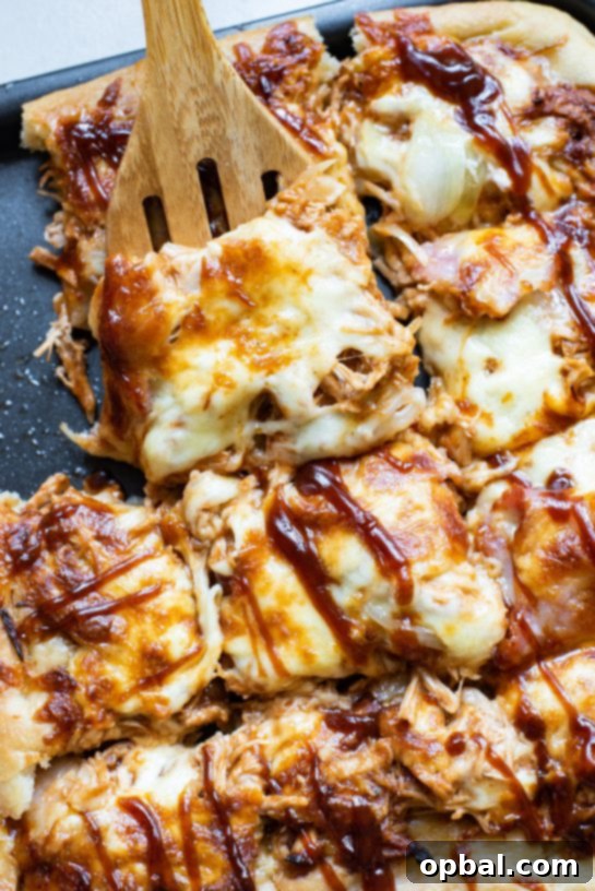 Easy, sweet, and savory Sheet Pan BBQ Chicken Pizza, showcasing its crispy crust and abundant cheese.