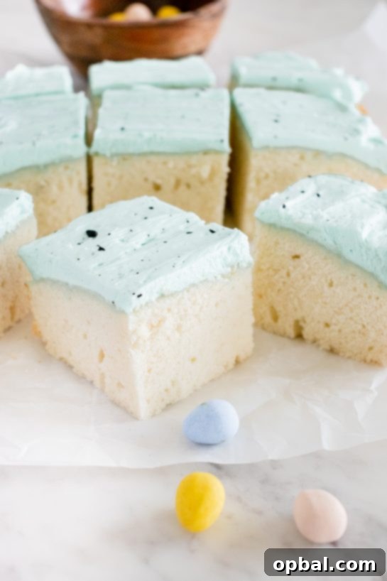 Robin's Egg Easter Cakelets 11 A close-up of a single slice of Easter Speckled Egg Snack Cake, showing the moist cake and blue frosting.