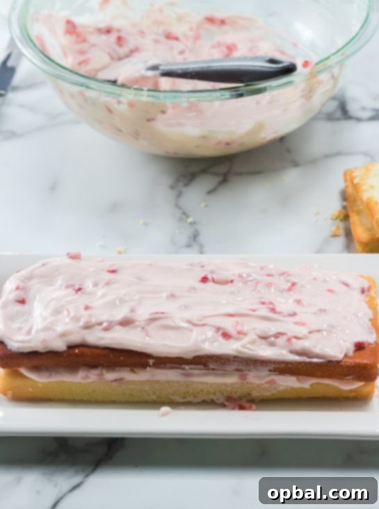 Strawberry Cloud Layer Cake 7 Cream cheese frosting being artfully applied to the Strawberries & Cream Layered Cake, preparing it for an Easter celebration.