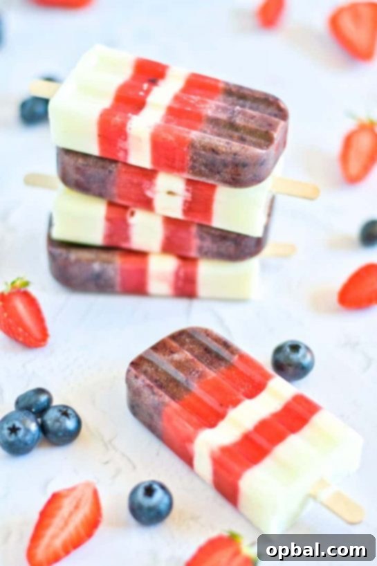 22 Firecracker Flavors for the Fourth 3 Healthy and refreshing Mixed Berry Popsicles recipe, perfect for cooling down on a hot 4th of July and featuring patriotic red, white, and blue colors.
