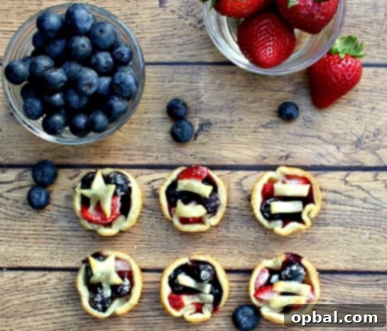 22 Firecracker Flavors for the Fourth 23 Easy Mini Berry Tarts recipe for the 4th of July, decorated with crust to look like flags for a festive display.