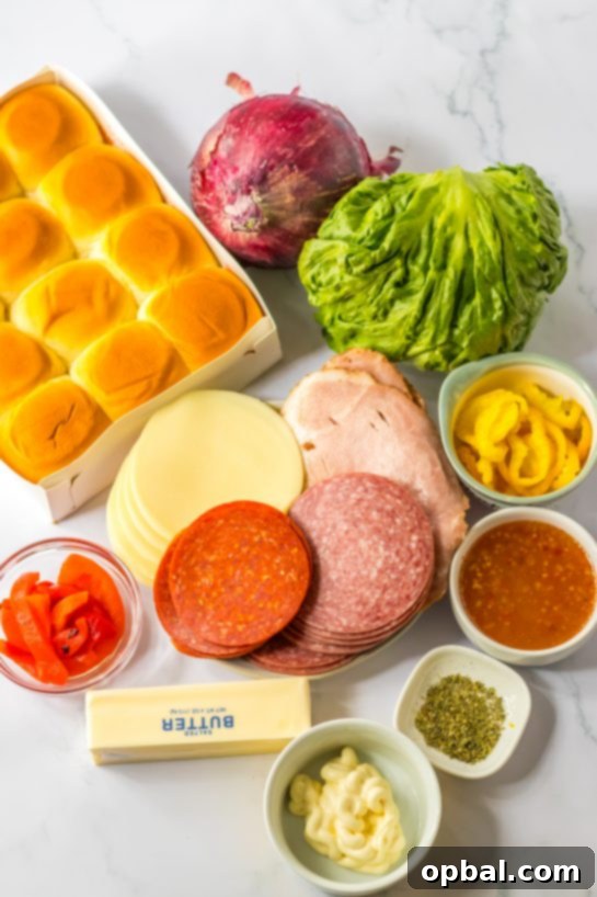 Zesty Italian Sliders 3 Ingredients laid out for making Italian Sub Sliders, including deli meats, cheese, rolls, and vegetables