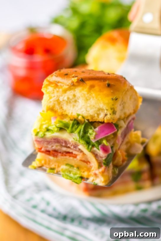 Zesty Italian Sliders 5 A tray of freshly baked Italian Sub Sliders with melted provolone cheese, ready for toppings