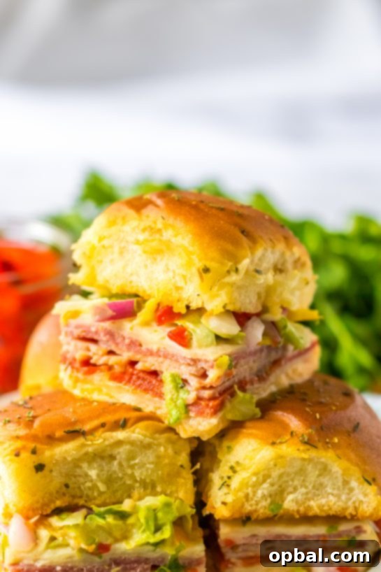 Zesty Italian Sliders 8 Close-up photo of a single Italian Sub Slider, highlighting the layers of meat, cheese, and fresh toppings