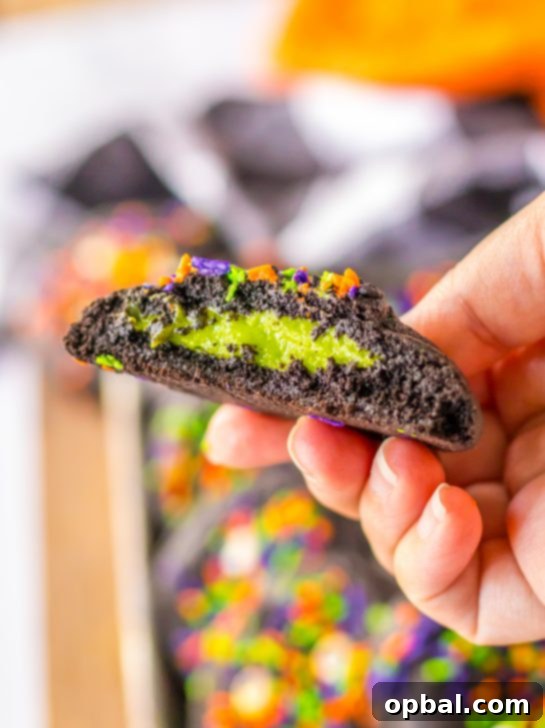 Midnight Velvet Stuffed Cookies 3 Stuffed Black Velvet Cookie split open to reveal vibrant green cheesecake filling, perfect for Halloween.