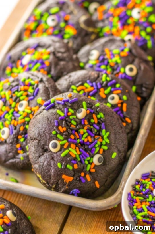 Midnight Velvet Stuffed Cookies 4 A stack of Stuffed Black Velvet Cookies with colorful Halloween sprinkles, ready for a spooky celebration.