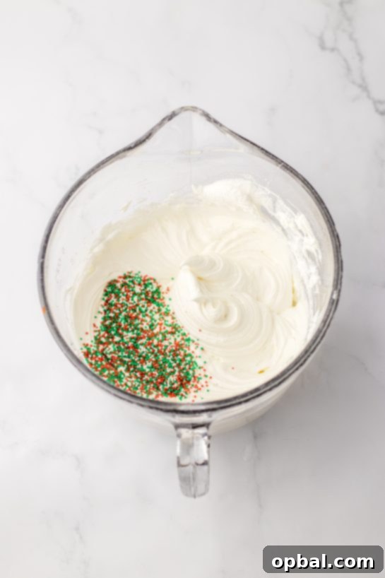 Yuletide Cookie Bliss 7 Mixing the creamy cheesecake layer with colorful holiday sprinkles, adding a festive touch to the Christmas Cookie Lush filling.