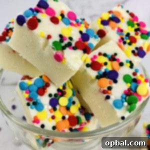 Vanilla Sugar Cookie Fudge 7 Close-up of freshly made Sugar Cookie Fudge, cut into perfect squares, showing its creamy texture and festive colorful sprinkles.
