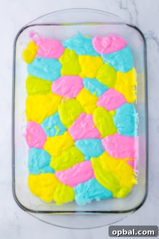 Springtime Easter Poke Cake 5 Pouring in the colored batter for the Easter poke cake recipe about to go into the oven.