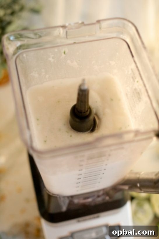 Zesty Coconut Lime Margarita Oasis 6 Coconut Lime Frozen Margarita ingredients being blended in a high-speed blender.