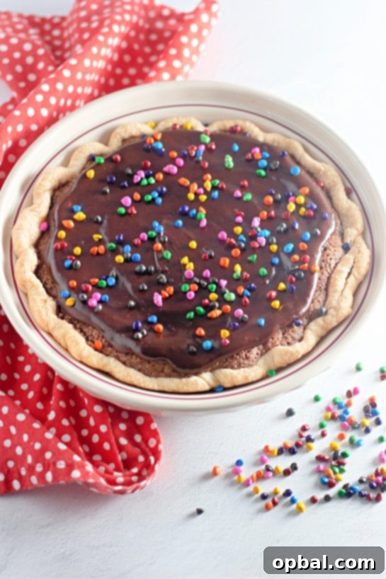 Starlight Sprinkled Brownie Pie 2 A beautifully sliced Cosmic Brownie Pie, revealing its rich fudgy interior and sprinkled topping. Served with a glass of cold milk, this pie promises dessert nirvana with its flaky crust and decadent chocolate filling.