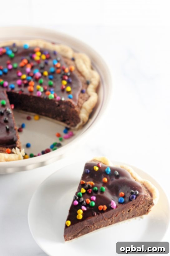 Starlight Sprinkled Brownie Pie 11 A tempting visual of a slice of Cosmic Brownie Pie plated in the foreground, with the remainder of the pie beautifully displayed in the background.