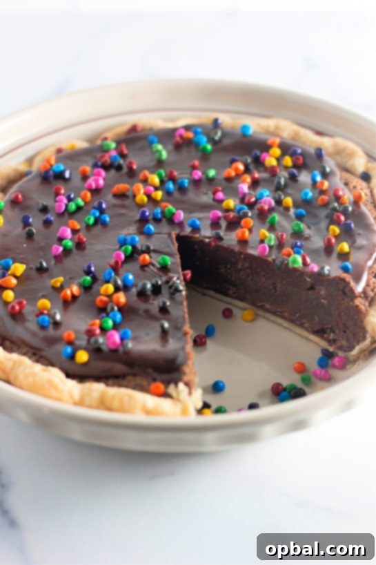 Starlight Sprinkled Brownie Pie 12 A close-up of a single slice of Easy Cosmic Brownie Pie, ready to be enjoyed, highlighting its rich layers and colorful topping.
