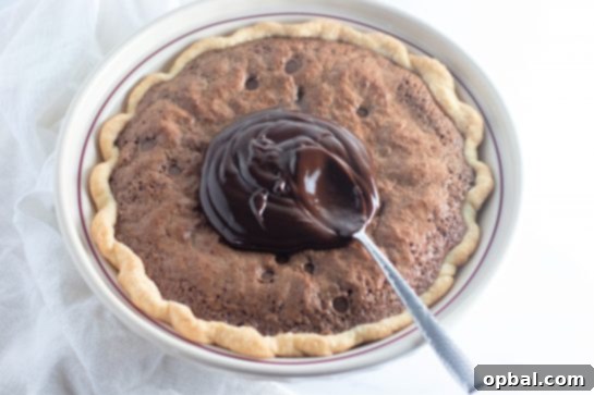 Starlight Sprinkled Brownie Pie 7 Smooth homemade chocolate ganache being generously spread over the cooled Cosmic Brownie Pie, adding another layer of rich chocolatey goodness.