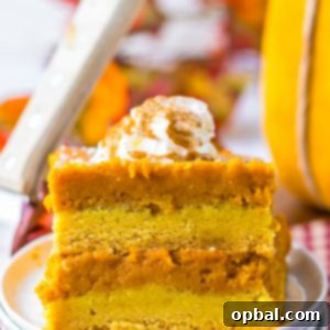 The ultimate Pumpkin Gooey Butter Cake, a classic fall and holiday dessert with a buttery cake mix crust and a luscious pumpkin-cream cheese filling, finished with powdered sugar and whipped cream.