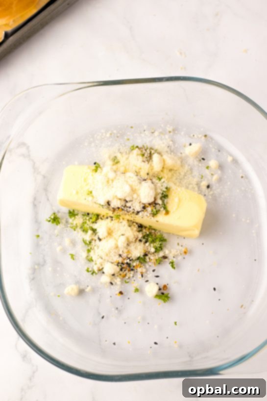 Melting butter with fresh parsley, Italian seasoning, and minced garlic for the TikTok stuffed bagels recipe.