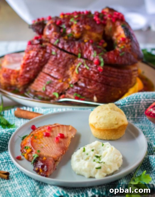 Christmas Glazed Ham 8 A plated slice of the finished orange, honey, and brown sugar glazed Christmas ham, garnished with festive elements, ready to be enjoyed.