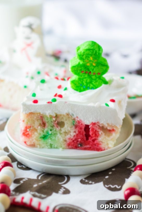 Holiday Spirit Poke Cake 8 Photo of a decorated slice of the finished Christmas Poke Cake recipe for the perfect holiday dessert