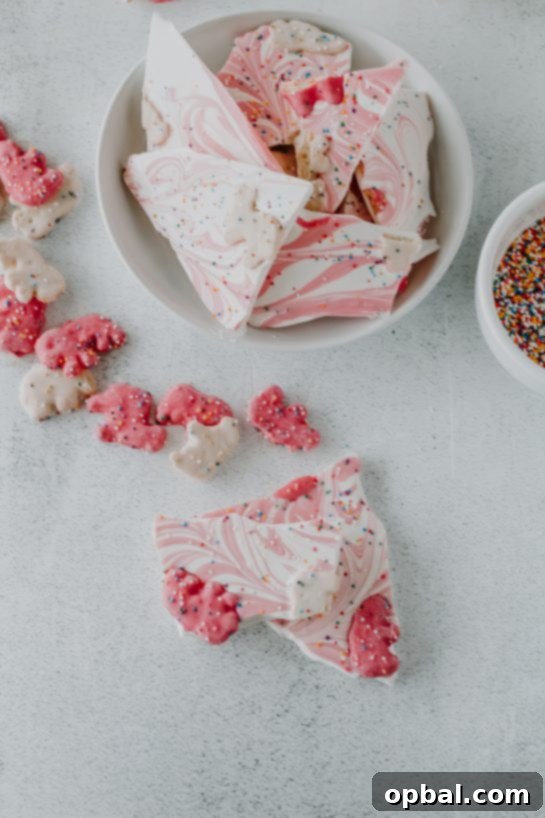 Festive No-Bake Animal Cracker Bark 5 Overhead view of the finished No-Bake Circus Cookie Bark dessert, showcasing colorful cookies and sprinkles.