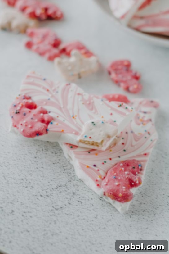 Broken pieces of No-Bake Circus Cookie Bark, showcasing the colorful cookies and sprinkles within.