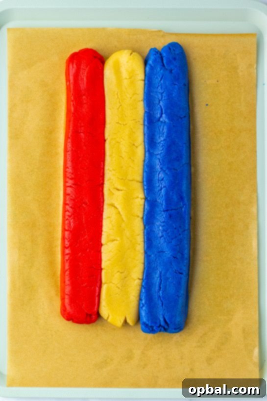 Firecracker Pop Cookies 4 Rolling out red, white, and blue dough layers to create Bomb Pop Cookies