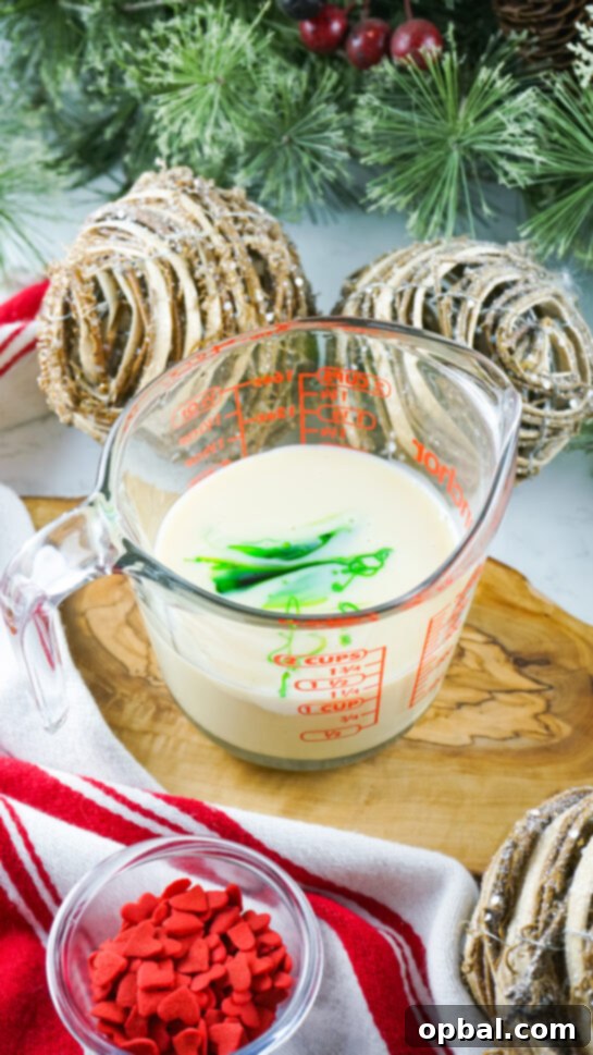 Mixing green food coloring into sweetened condensed milk for Grinch Fudge.
