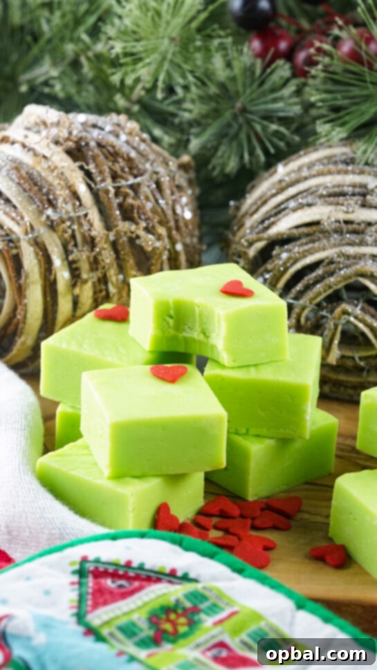 Finished Grinch Fudge with heart sprinkles; a bite taken from a piece.
