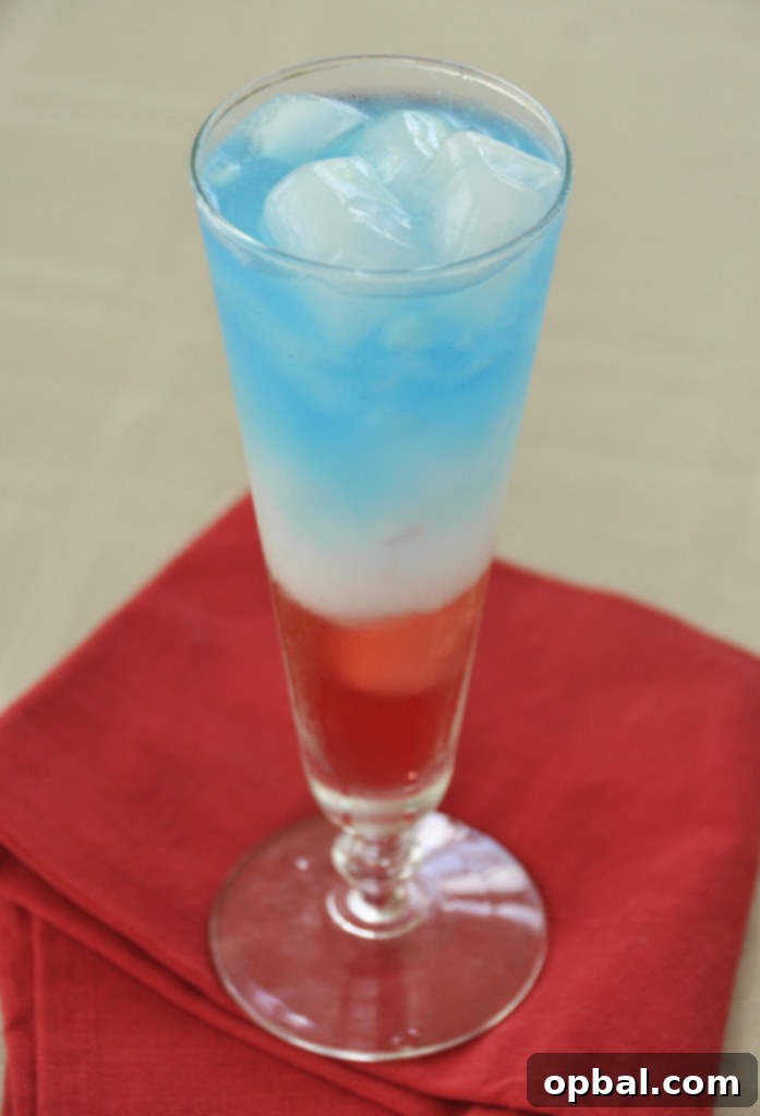 Vibrant Layered Patriotic Non-Alcoholic Drink for 4th of July celebrations, perfect for all ages.