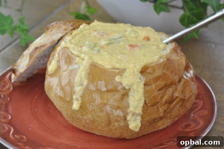 Golden Broccoli Cheddar Bliss 2 A hearty bowl of creamy homemade Panera Bread style broccoli cheddar soup in a rustic bread bowl, garnished with fresh herbs, perfect for a comforting meal.