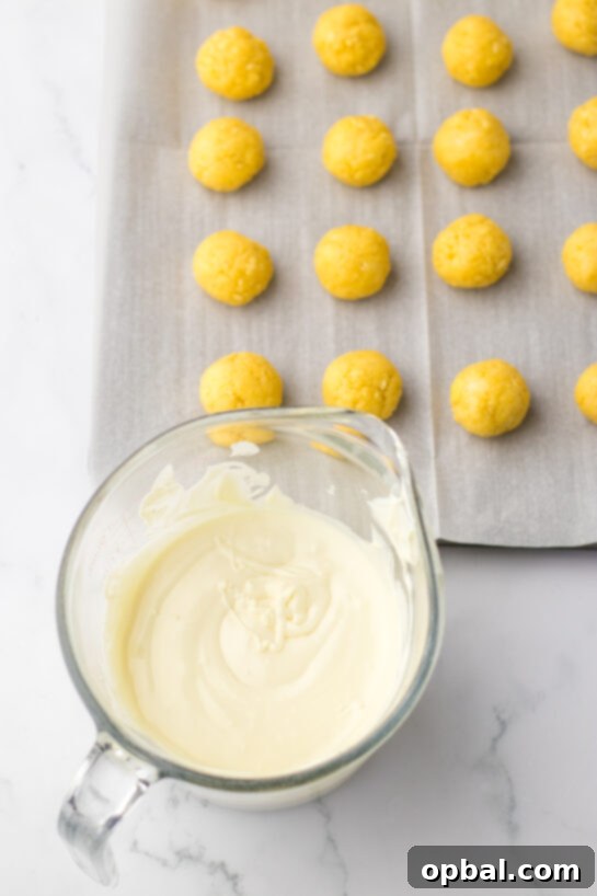 Lemon Pompom Truffles 5 Ready to dip the cake balls in the melted white chocolate to make the bunny butt lemon truffles recipe for Easter.