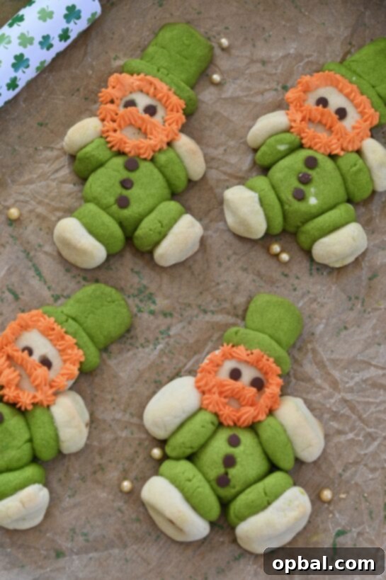 Leprechaun's Lucky Cookie Delights 2 Irresistibly cute Lucky Leprechaun Cookies with green and white sugar cookie dough, mini chocolate chip buttons, and fluffy orange frosting beards, perfect for St. Patrick's Day celebrations.